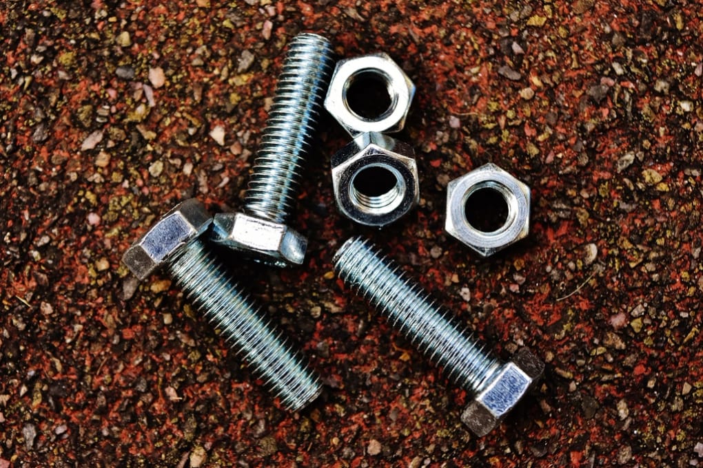 A dense bed of machined fasteners, the kind of population a 100% inspection covers.